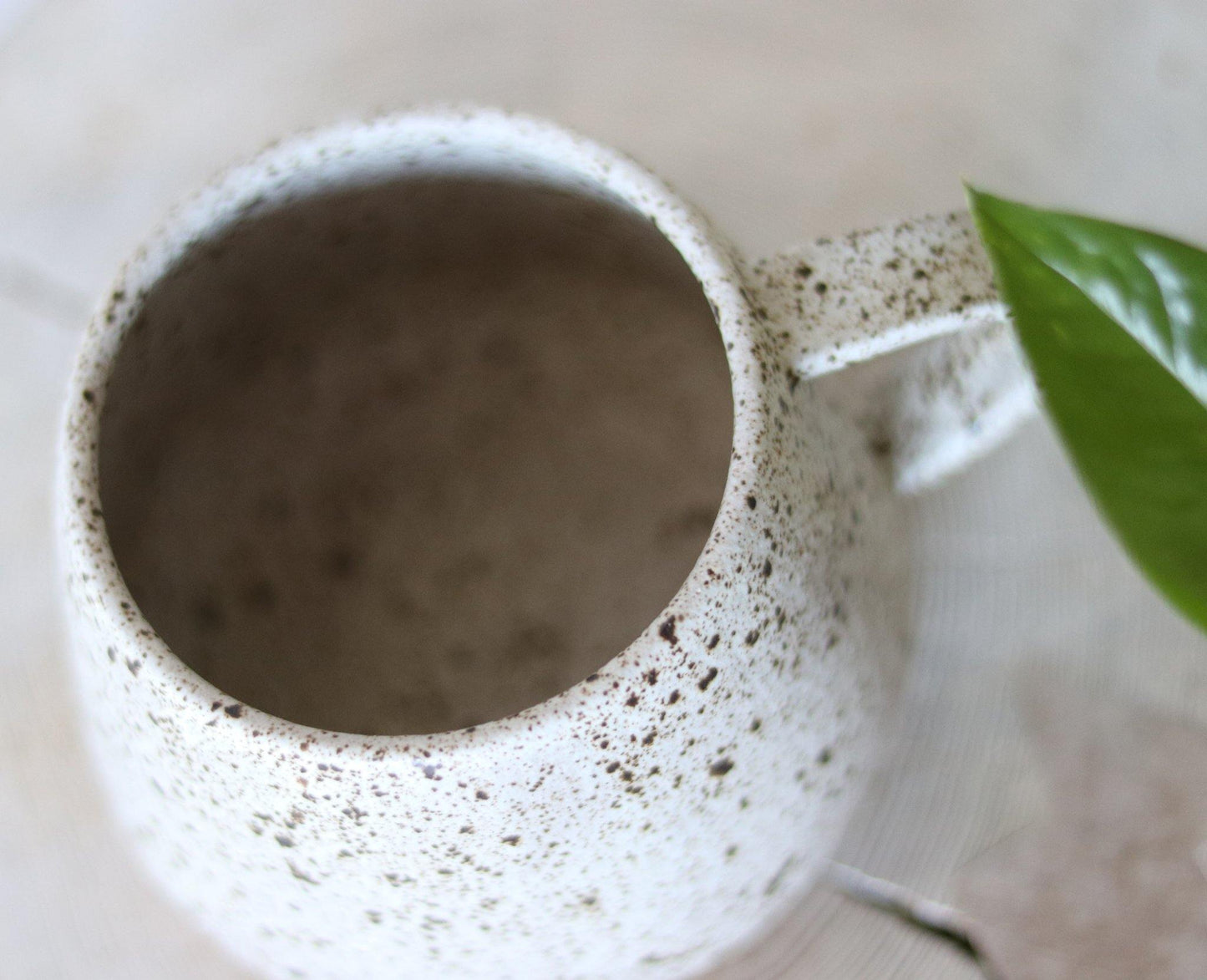 Handmade neutral stoneware mug with a speckled clay body and quail speckled glaze. Made by void and form ceramics.