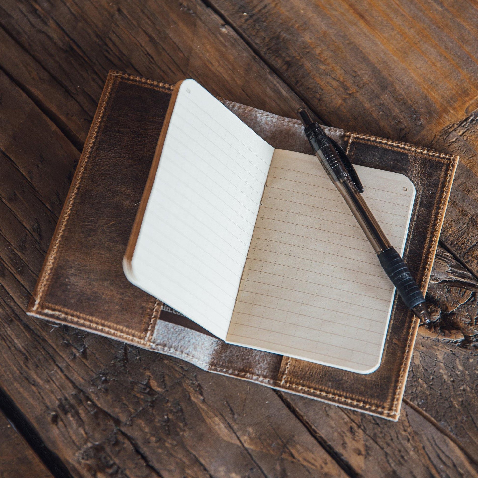 Leather notebook cover with beige notebook and black pen