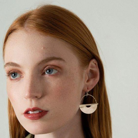 Brass hoop earrings on model