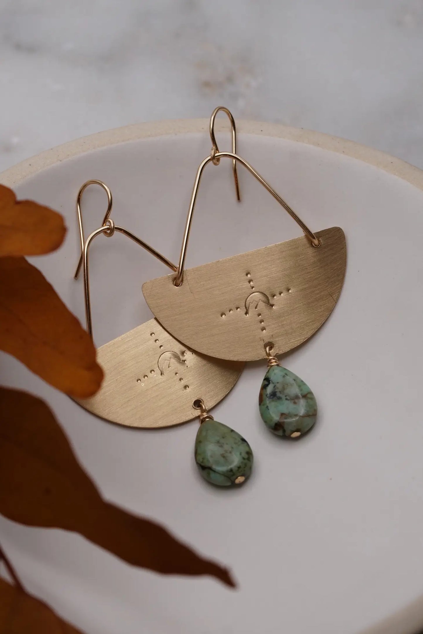 gold dangle earrings with mountain design and turquoise teardrop gem