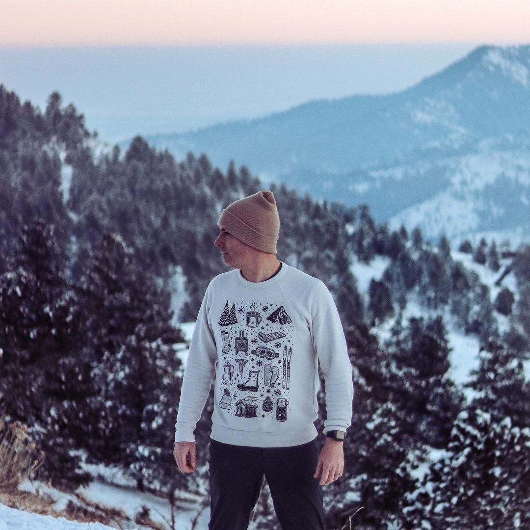 man wearing Oatmeal colored crew neck sweatshirt featuring winter activities