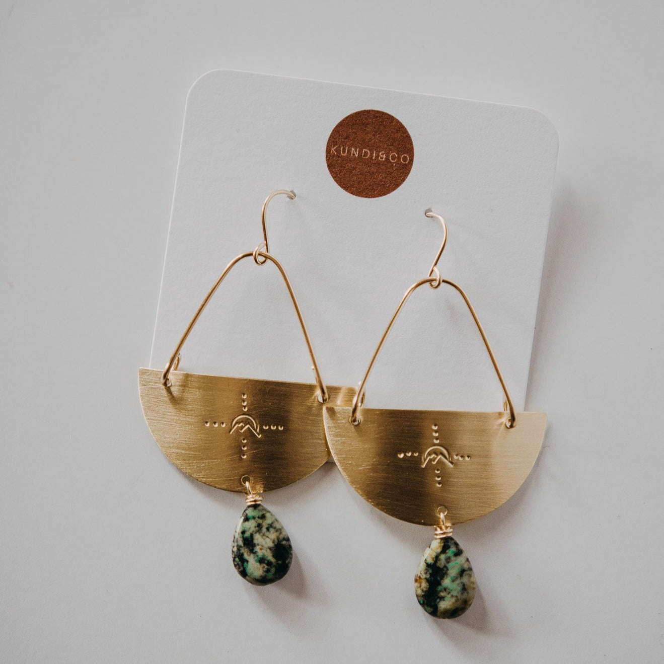 gold dangle earrings with mountain design and turquoise teardrop gem