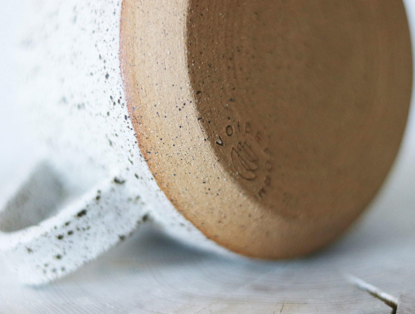 Handmade neutral mug with a speckled clay body and quail speckled glaze. Made by void and form ceramics.